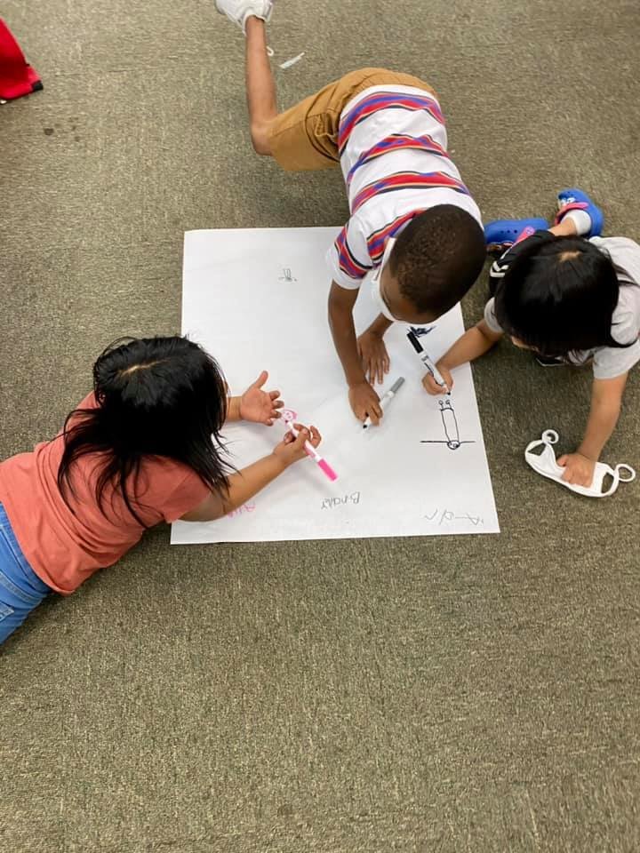 K-5 students team up to make posters before classroom election.